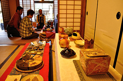 町家の民家を会場に開かれている陶芸同好会の作品発表会。通りに面した格子から光が差し込む