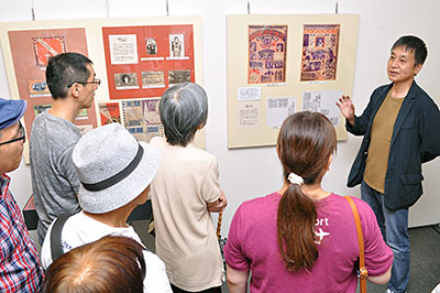 展覧会会場で来場者に展示資料の解説をする鵜飼正樹教授＝2019年8月24日、奈良県大和郡山市北郡山町のやまと郡山城ホール