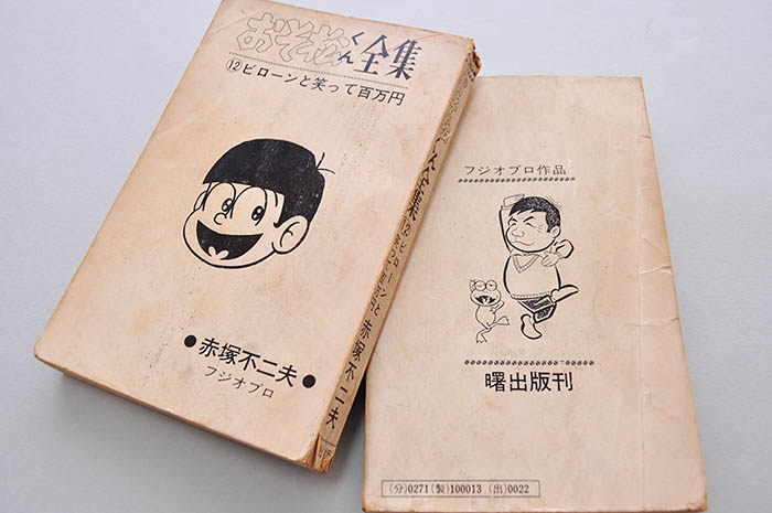 1960年代に曙出版が刊行した赤塚不二夫作品（記者蔵）。裏表紙には自画像があしらわれている（右）