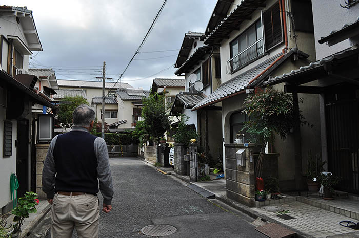 歴史体験学習館計画で立ち退きの対象になっている住宅地に立つ自治会長の男性＝2020年11月10日、奈良市