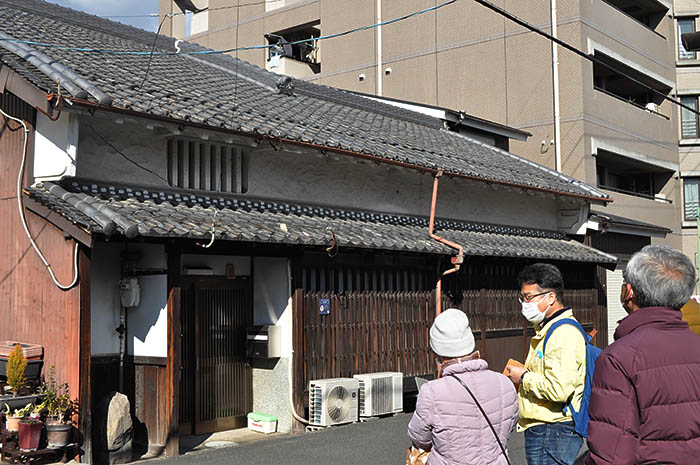 スマートフォンを手に城下町の町並みを歩く催しの参加者＝2022年3月6日、奈良県大和郡山市