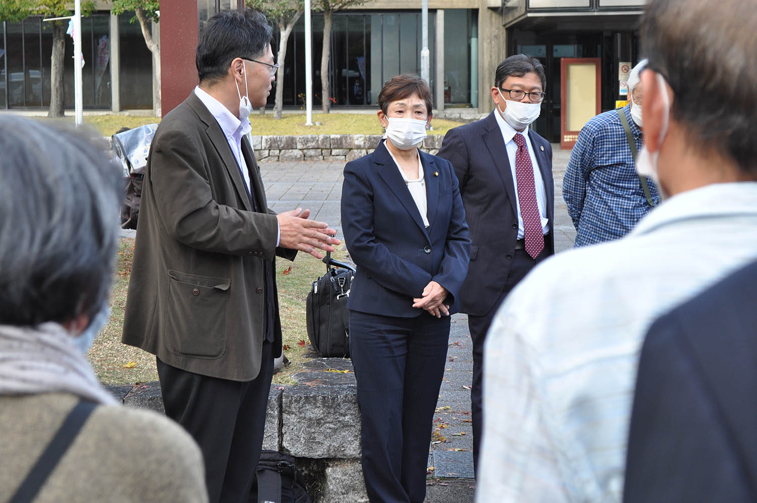 口頭弁論終了後、支援者へのあいさつに臨む青木恒子香芝市議（左から3人目）＝2022年11月24日、奈良市の県文化会館前