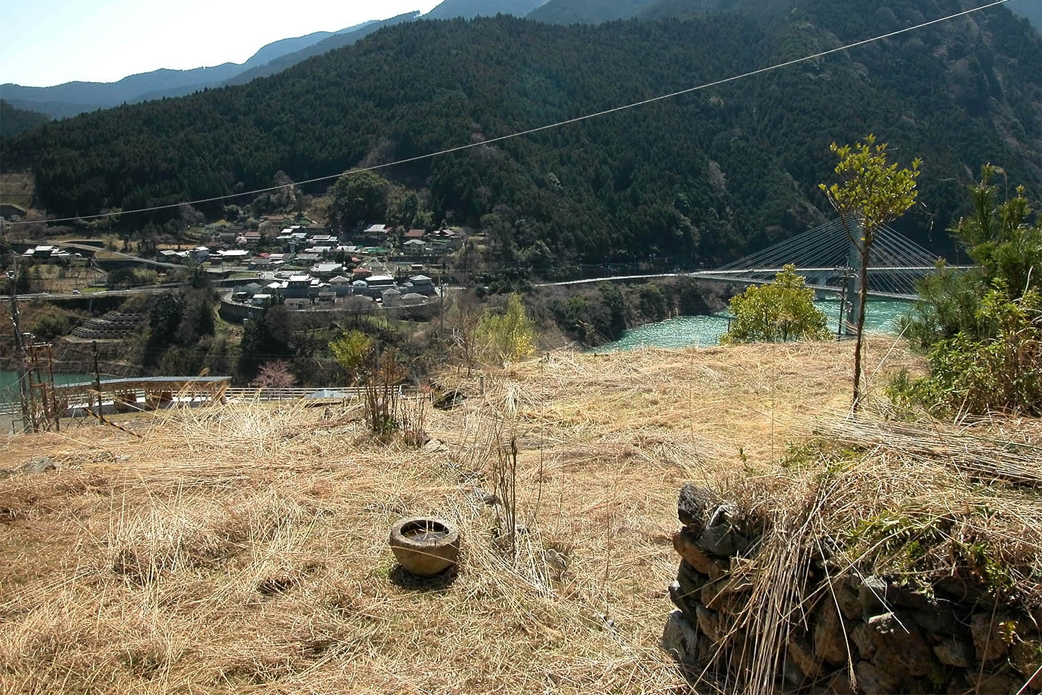 大滝ダム地滑りで廃虚になった集落。元屋敷の石垣、ちょうず鉢が生々しく残っていた＝2015年4月、川上村白屋