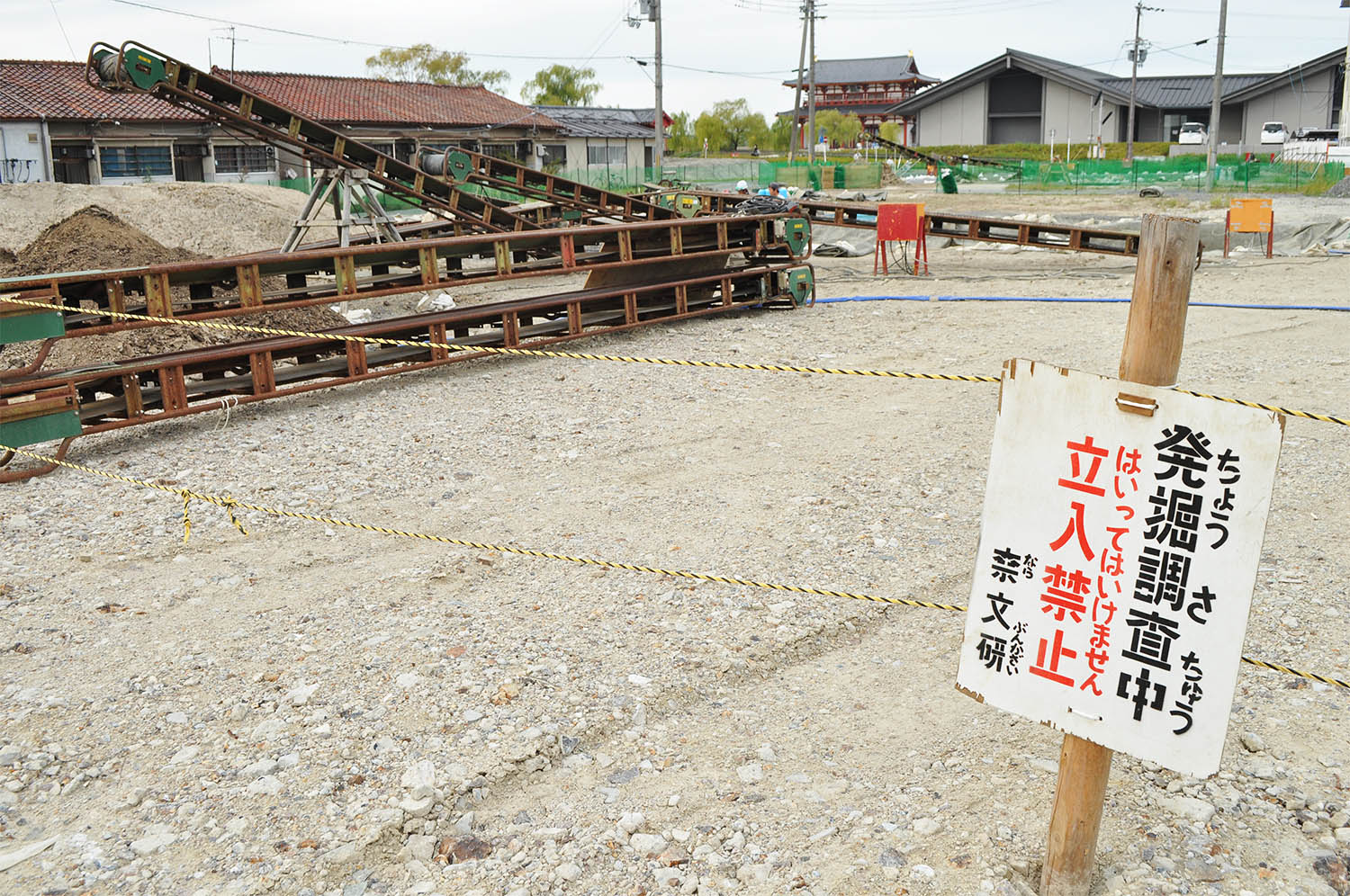 発掘調査が行われている歴史体験学習館予定地。奥は平城宮跡に復元された朱雀門＝2022年10月、奈良市二条大路南3丁目