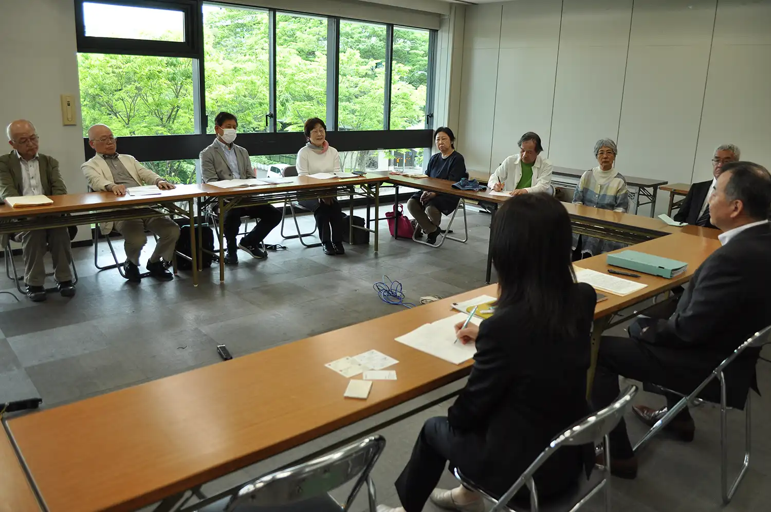 奈良県の担当者（右手前）に条例案を提出して要望を伝える「ヘイトスピーチ規制条例制定を実現する会」の人たち＝2024年5月15日、県庁