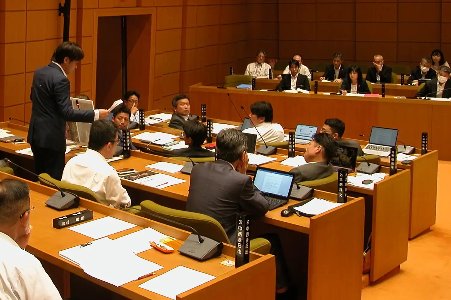 水道の配水形態のパネルを掲げながら質問する山本議員＝2024年6月11日、奈良市二条大路南1丁目の市議会
