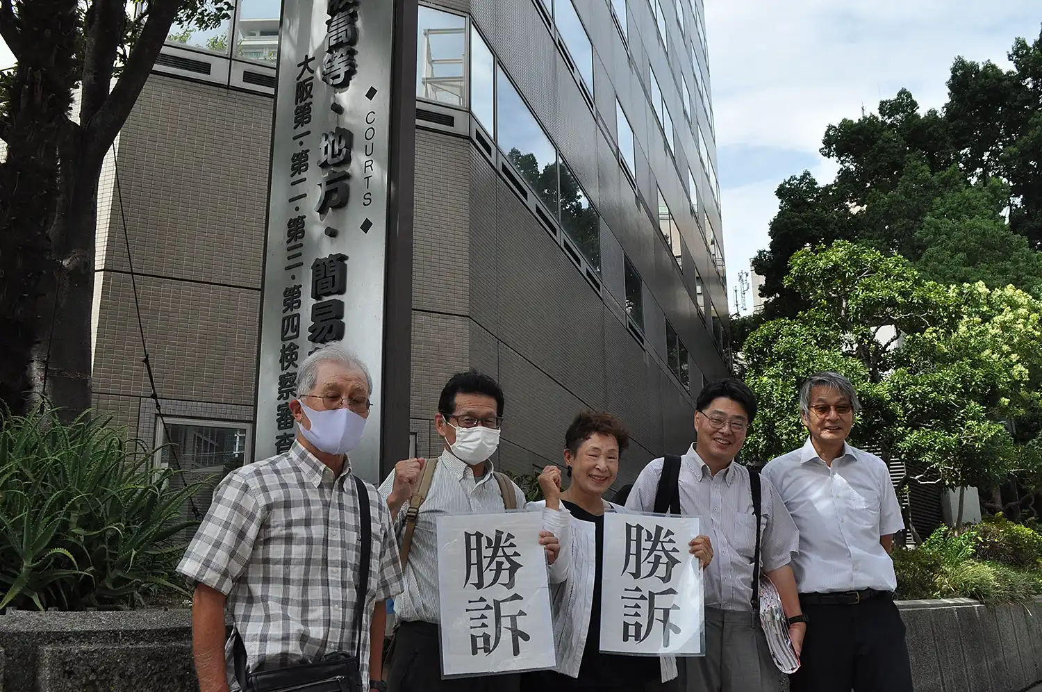 判決を受けて「勝訴」を喜ぶ青木恒子議員（中央）や弁護士、支援者＝2024年8月28日、大阪市の大阪高裁前