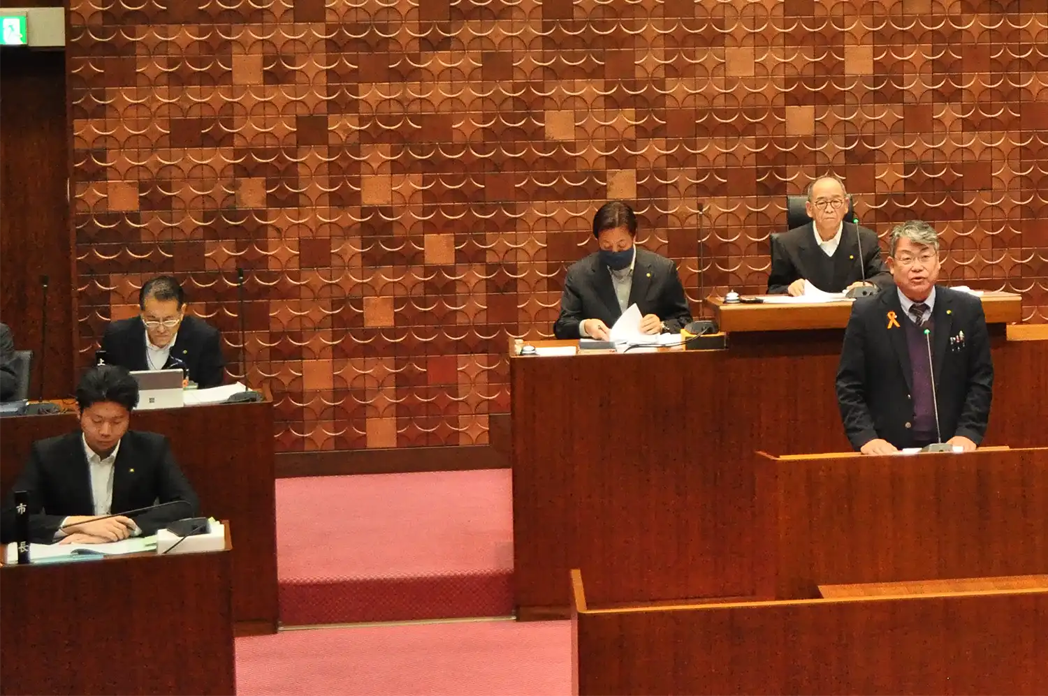 議会基本条例の改正案の提案理由を説明する筒井寛議員（手前右）。手前左は三橋和史市長＝2024年12月25日、奈良県香芝市議会、浅野善一撮影