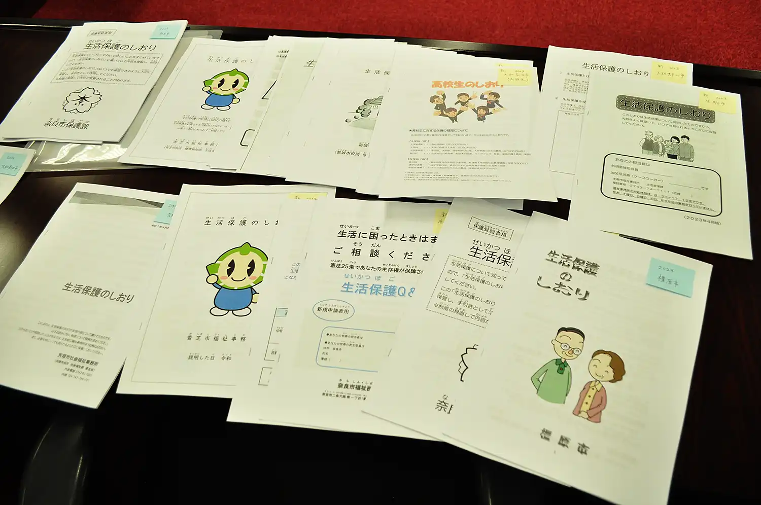 奈良県内自治体の福祉事務所それぞれの「生活保護のしおり」＝2025年8月21日、奈良市中筋町の奈良弁護士会館、浅野善一撮影